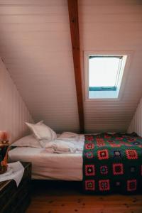 a bedroom with a bed in a attic with a window at Tanginn in Stykkishólmur
