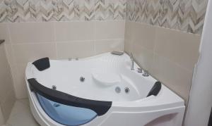 a white bath tub with a blue seat in a bathroom at Indira Villa 3 in Roche Terre