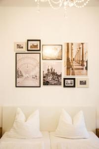 a gallery wall of pictures on a wall above a bed at Apartmá Zeyer 1887 in Karlovy Vary