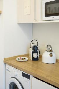 a kitchen counter with a washing machine and a microwave at Apartmá Zeyer 1887 in Karlovy Vary
