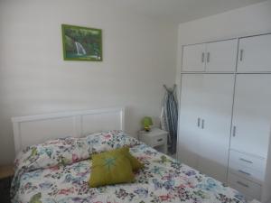 ein Schlafzimmer mit einem Bett mit gelbem Kissen darauf in der Unterkunft L'auberge étoilée in Morne-à-lʼEau
