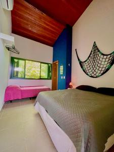 ein Schlafzimmer mit einem Bett und einem Fenster in der Unterkunft Delícia de casa em Barra do Una a 5 min de Juquehy! in São Sebastião