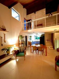 ein Wohnzimmer mit Tisch und ein Esszimmer in der Unterkunft Delícia de casa em Barra do Una a 5 min de Juquehy! in São Sebastião