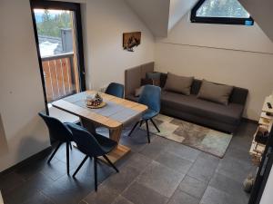 a living room with a table and a couch at Apartma A1 GOLTE in Mozirska Koča