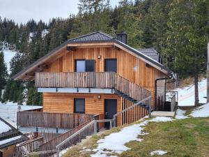 a log cabin with a staircase leading to the front door at Apartma A1 GOLTE in Mozirska Koča