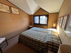 een slaapkamer met een bed in een kamer met een raam bij Appartamento vista Alpi nel centro storico in Sauze dʼOulx