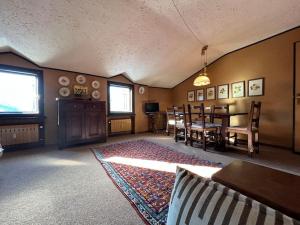 a living room with a table and a dining room at Appartamento vista Alpi nel centro storico in Sauze dʼOulx