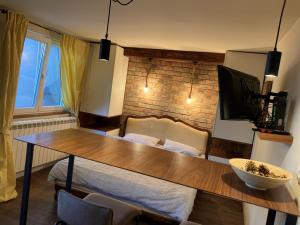 a living room with a table and a tv on a wall at Little L Apartments Dorćol in Belgrade