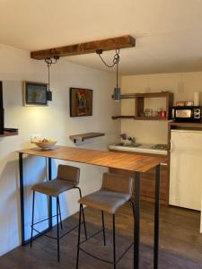 a kitchen with a wooden table and two stools at Little L Apartments Dorćol in Belgrade