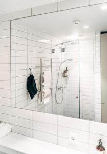 a bathroom with a shower and a large mirror at UNITY Tampere Trikootehdas in Tampere