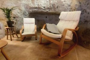 two rocking chairs in a room with a stone wall at Troglo entre Caves et Châteaux in Montlouis-sur-Loire