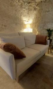 un sofá blanco con almohadas en la sala de estar en Troglo entre Caves et Châteaux en Montlouis-sur-Loire