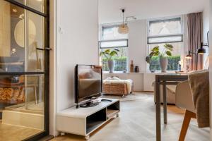 Knus appartement in sneek في سنيك: غرفة معيشة مع تلفزيون يجلس على طاولة