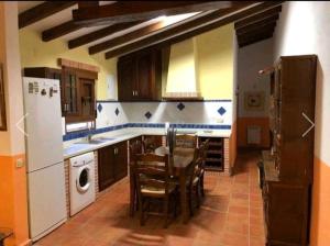 een keuken met een tafel en stoelen en een koelkast bij Casa rural Loma de las Veredas in Ossa de Montiel