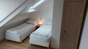 a attic room with two beds and a table at Appartement met 3 slaapkamers vlakbij strand en centrum in Zoutelande
