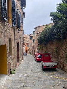a street with two cars parked in a alley at La finestra sulla Torre in Siena