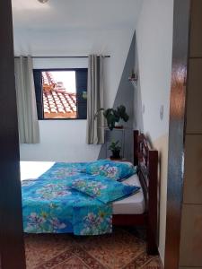 1 dormitorio con cama y ventana en Casa de temporada em São Tomé das Letras, en São Thomé das Letras