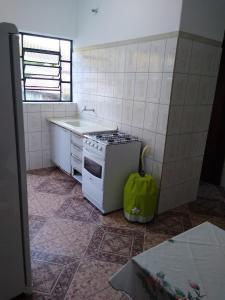 una pequeña cocina con fogones y fregadero en Casa de temporada em São Tomé das Letras, en São Thomé das Letras