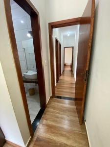 a hallway of a bathroom with a sink and a mirror at Casa Jatobá da Serra in Serra do Cipo