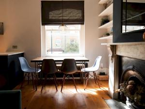 倫敦的住宿－Pass the Keys Stylish cosy 2bed near Finsbury Park w balcony，一间带桌椅和窗户的用餐室