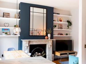 a living room with a fireplace and a mirror at Pass the Keys Stylish cosy 2bed near Finsbury Park w balcony in London