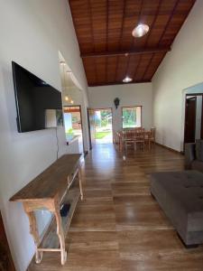 a living room with a wooden table and a couch at Casa Jatobá da Serra in Serra do Cipo