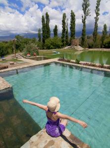 a woman is standing in front of a swimming pool at Finca Huayrapuca in Famatina
