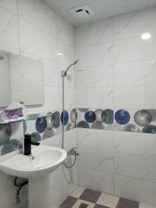 uma casa de banho branca com um lavatório e um chuveiro em Flower B&B em Hualien
