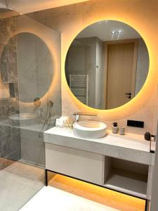 uma casa de banho com um lavatório e um espelho grande em HEAVEN HILLS 25 - connection of nature and luxury em Bjelašnica