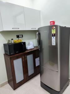 a kitchen with a stainless steel refrigerator and a microwave at 1BHK AC Service Apartment 202 in Pune