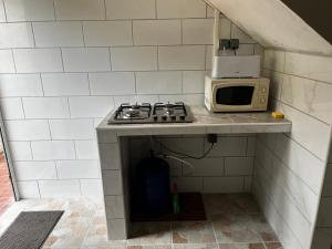 a small kitchen with a stove and a microwave at L'Escale du Mouillage in Saint-Pierre