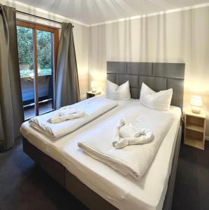 ein Schlafzimmer mit einem Bett mit Handtüchern darauf in der Unterkunft Wiefarn Apartments - Ferienwohnungen in Bad Wiessee am Tegernsee in Bad Wiessee
