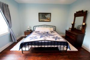 a bedroom with a bed and a dresser and a mirror at Cozy, historic 5-bedroom home in Amish country in Smicksburg