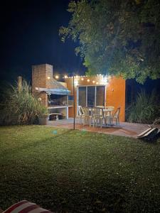 un patio con mesa y sillas frente a una casa en CASA OCTUBRE, en Aguas Dulces
