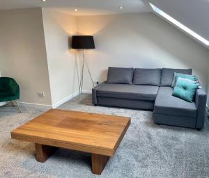 a living room with a blue couch and a coffee table at Vennel Street Apartments in Stewarton