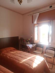 1 dormitorio con cama, mesa y ventana en Antico Portale - Host Roberto, en Regalbuto