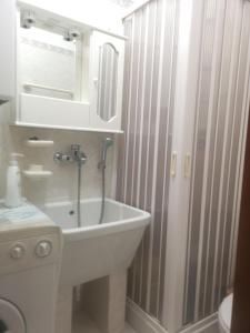 ein Badezimmer mit einer Badewanne, einem Waschbecken und einem Spiegel in der Unterkunft Antico Portale - Host Roberto in Regalbuto