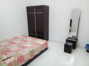 een slaapkamer met een bed, een dressoir en een spiegel bij Percutian Di Taiping & Bukit Merah Laketown in Kamunting