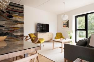 Una sala de estar con una mesa y sillas amarillas. en W Apartments Kalaranna I, en Tallin