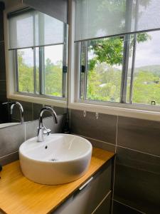 a bathroom with a sink and two windows at Eumundi Cottage in Town in Eumundi