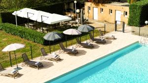 a group of chairs and umbrellas next to a pool at Château de Fontanges in Onet le Château