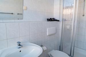 La salle de bains est pourvue d'un lavabo, de toilettes et d'un miroir. dans l'établissement Nauticus, à Rostock