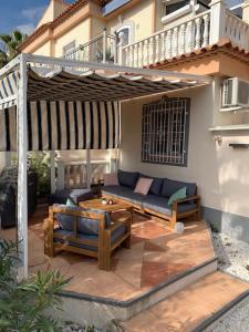 eine Terrasse mit einem Sofa und einem Tisch vor einem Haus in der Unterkunft Schönes Ferienbungalow in Los Altos Torrevieja in Torrevieja