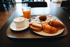 un plato de desayuno con una taza de café y bollería en Hotel kommod, en Ruggell