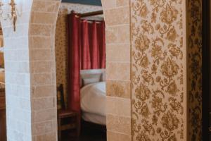 Habitación con vistas a un dormitorio con cama y cortinas rojas. en LA SALLE DES SORTILÈGES, en Perpiñán