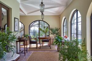 un soggiorno con tavolo, sedie e finestre di Deux Frères Wine Estate & Luxury Villas a Stellenbosch