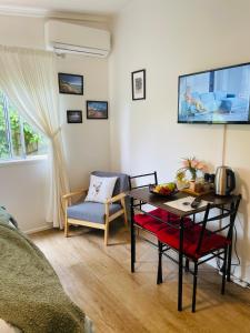 ein Wohnzimmer mit einem Tisch und einem Stuhl in der Unterkunft Eumundi Cottage in Town in Eumundi