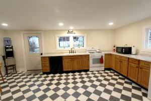 a kitchen with a checkered floor and a stove at Cozy, historic 5-bedroom home in Amish country in Smicksburg