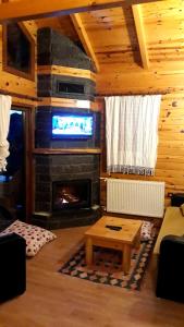 a living room with a fireplace and a tv at Ayder Cise Dag Evleri in Ayder Yaylasi