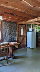 a kitchen with a table and a refrigerator in a cabin at Mirador del Valle in Lago Puelo